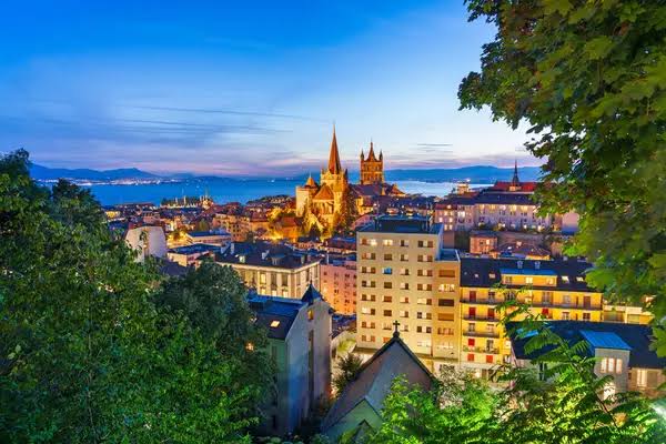 La cathédrale de Lausanne et la ville au crépuscule, le Léman en arrière-plan